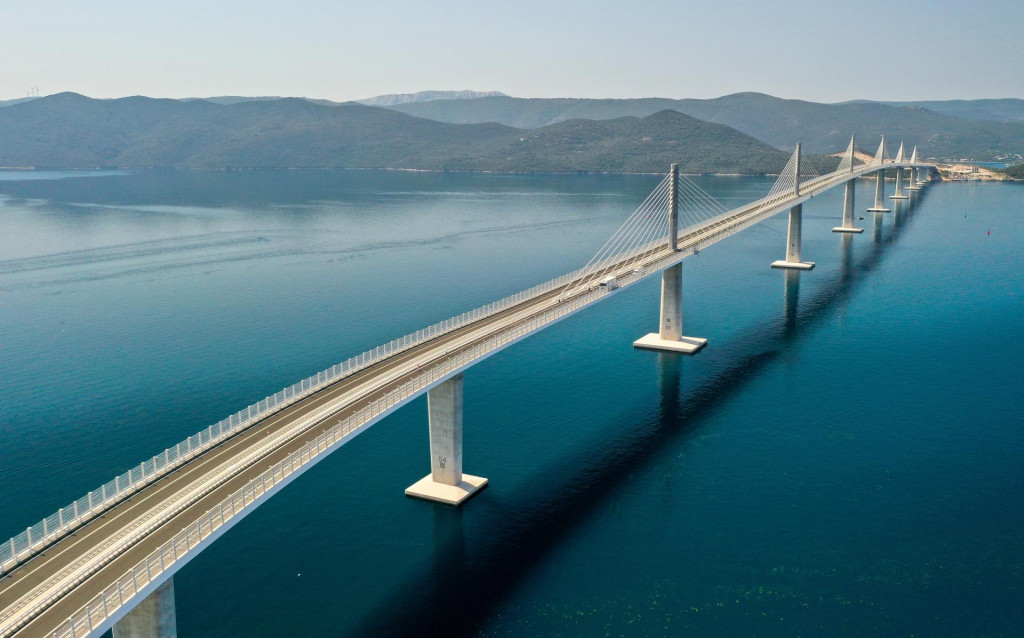&lt;p&gt;Komarna, 26.07.2022 - Pelješki most dužine 2404 metara koji spaja južni dio Hrvatske sa ostatkom domovine snimljen iz zraka. Na slici Pelješki most, most, tabla, građevina, ilustracija.&lt;/p&gt;
